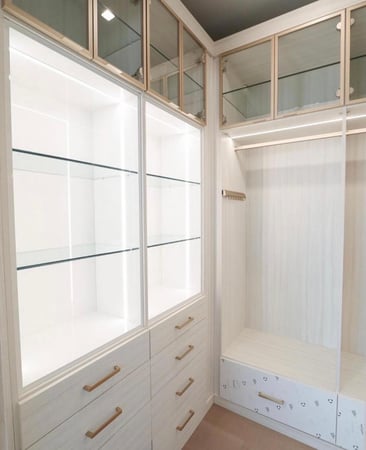 Luxe walk in closet with glass doors and gold hardware. Increase closet organization with California Closets Toledo, Ohio.