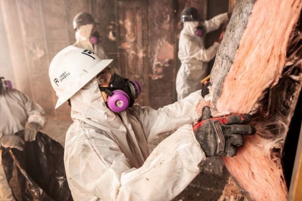 Professional removes damaged insulation as part of fire and smoke restoration.