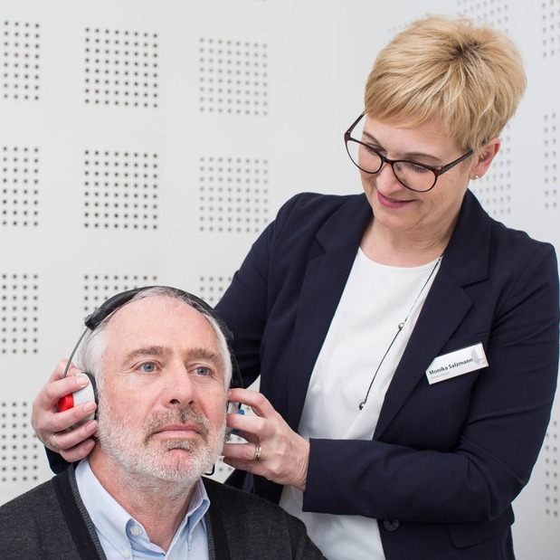 Hörakustikerin führt eine kostenlose Hörmessung bei einem Kunden durch.