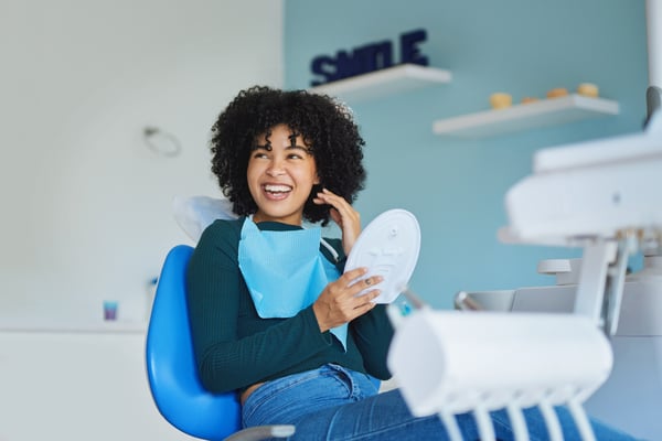 Person smiling in a dental chair.