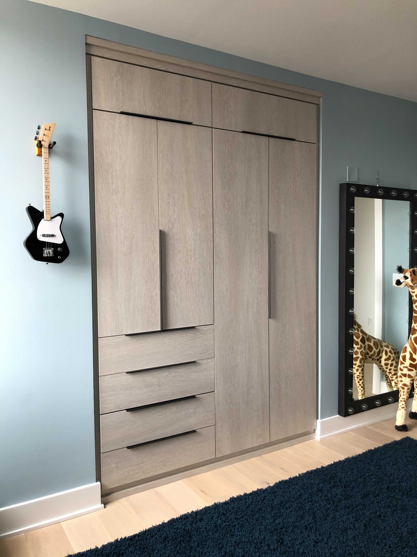 wardrobe closet with slab doors and drawers in a grey finish