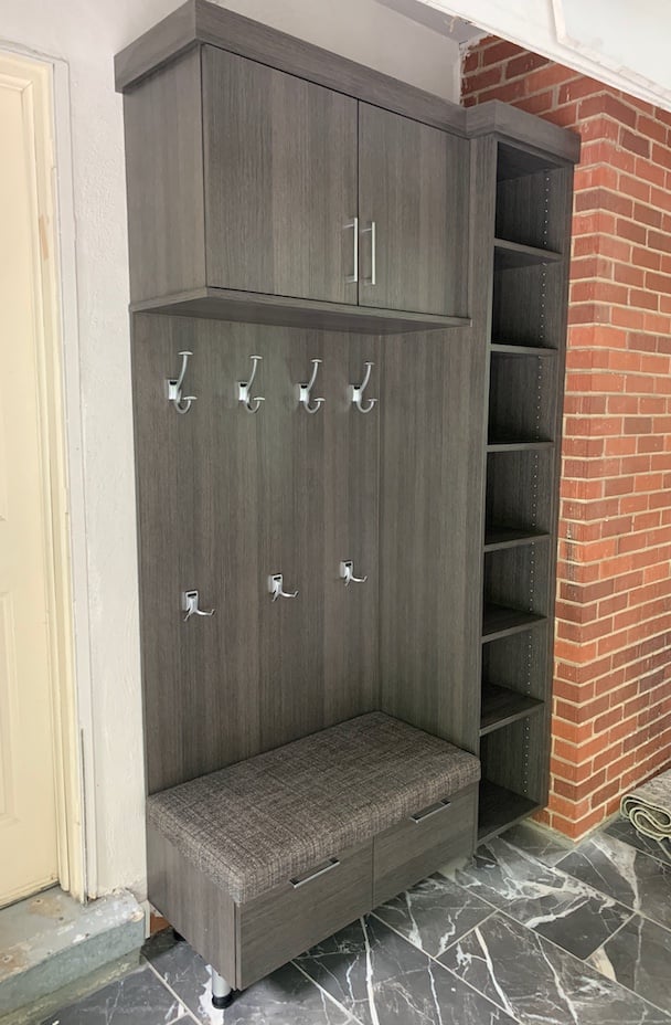 Custom mudroom storage with built-in bench, coat hooks, and upper cubbies.
