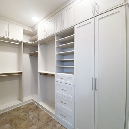 Walk in closet with floor to ceiling storage. A combination of hanging, open shelving, and closed storage complete this space.