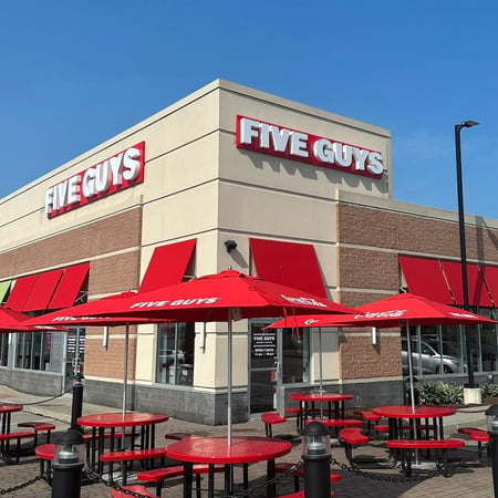 Exterior image of the entrance to the Five Guys restaurant at 878 Stillwater Avenue in Bangor, Maine.