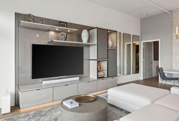 Earth tone media center in living room, with beige couch, chandelier, and mirrors