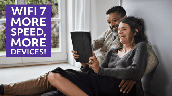 Man and woman smiling while looking at a tablet