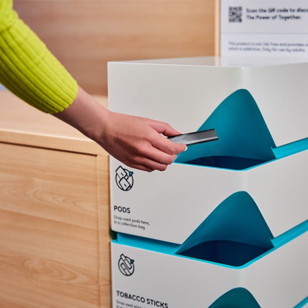 Osoba wrzucająca zużyty wkład do specjalnego pojemnika na recykling