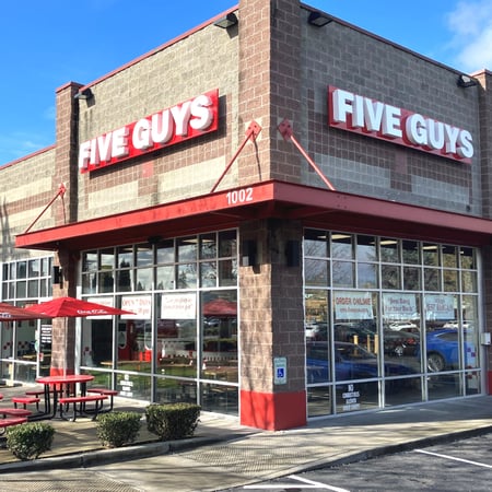 Exterior photograph of the Five Guys restaurant at 1002 N. Meridian Street in Puyallup, Washington.