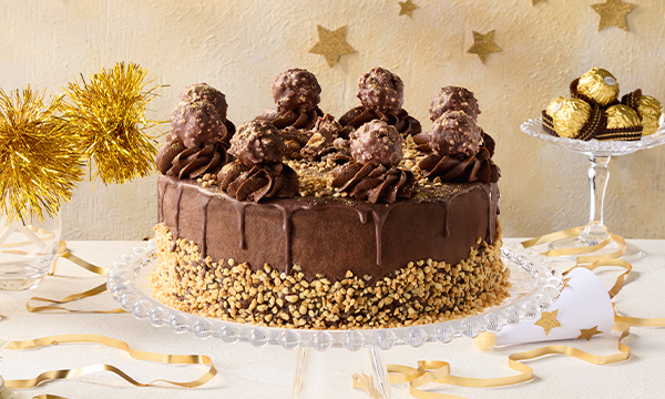 The NEW Ferrero Rocher® ice cream cake from Milky Lane on a glass plinth with a gold themed celebration background.