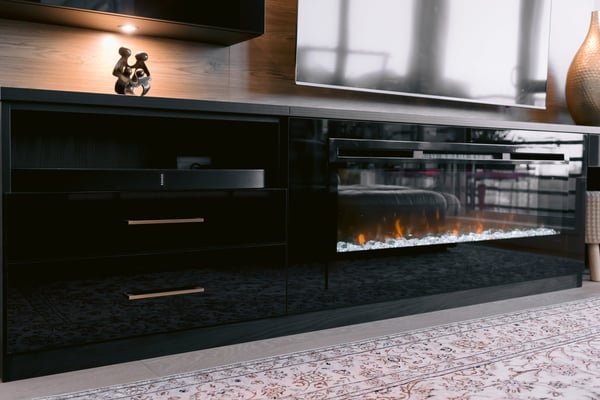 Close up view of drawers, a shelf for electronics and an electric fireplace