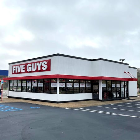 Exterior photograph of the Five Guys restaurant at 4663 Airport Boulevard in Mobile, Alabama.