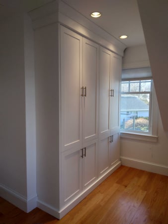 Built-in wardrobe with floor-to-ceiling storage in white.