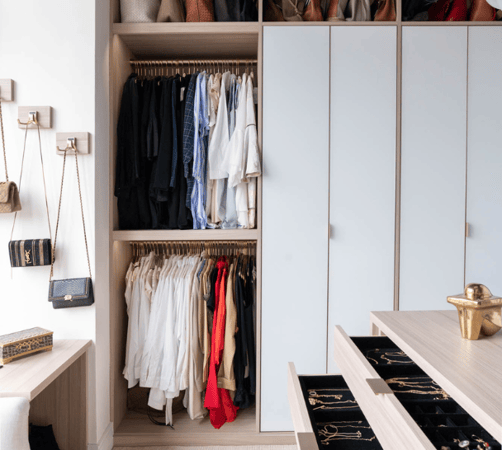 full room walk-in closet with open and closed cabinetry white & natural wood combo with island in center and dedicated jewelry drawer storage Upper East Side NYC