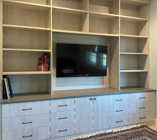 Entertainment center with drawers, cabinets, and shelving in medium wood by California Closets Pasadena.