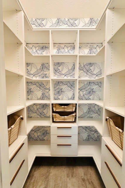 Custom pantry in Dove finish with wall-mounted design, gold baskets with canvas liners, and Paxton handles for a refined, organized storage solution.
