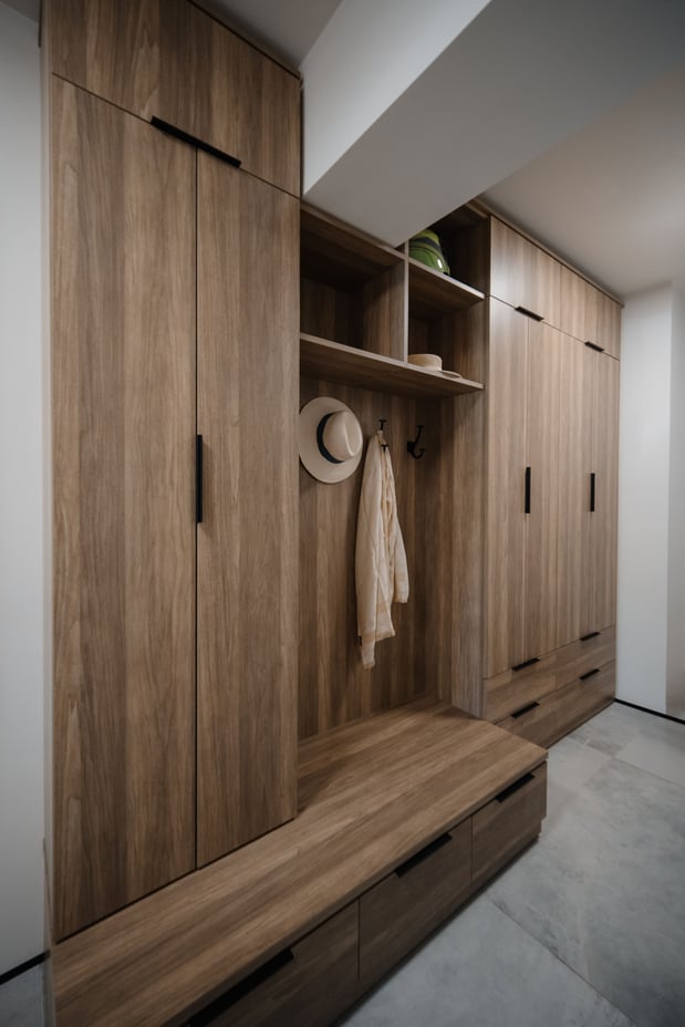 Rich wood grain mudroom with bench and floor-to-ceiling cabinets