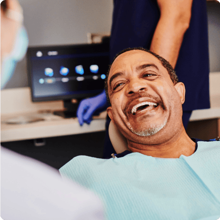 Do dental implants hurt? Man smiling at dentist.