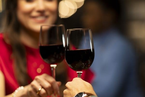 a cheers with 2 red wine glasses