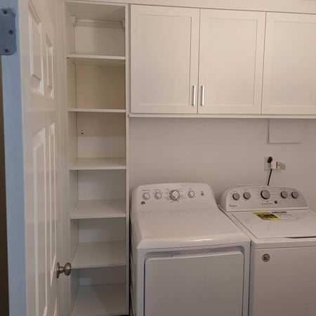 Floor-to-ceiling shelves located next to the washer and dryer.