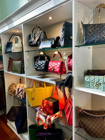 Custom purse shelving with lighting and glass shelving.
