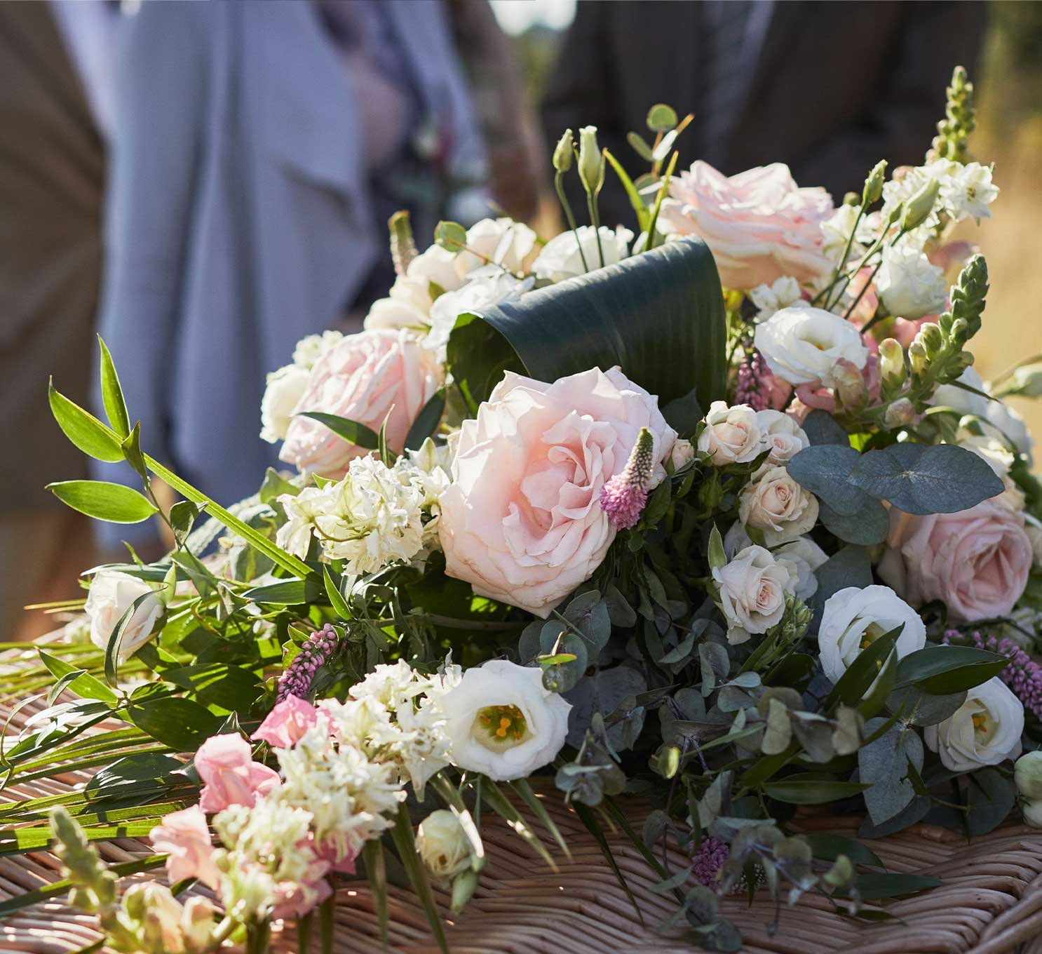 A classic spray of flowers rests upon a bamboo coffin.