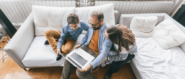 family using laptop on couch