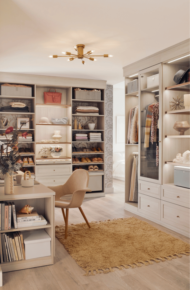 Custom Walk-In Closet with Built-In Desk Vanity Open Shelving Drawer Storage Glass Front Cabinets Hanging Sections Light Wood Cabinetry by California Closets South Palm Beach Florida