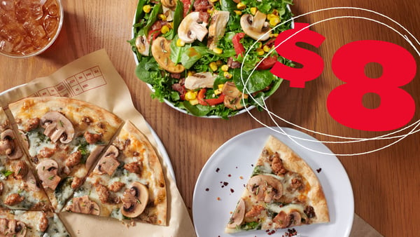 Top down view of a table with our new Super Shroom Pizza and Salad.