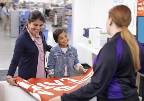 Woman and her daughter getting a banner printed at a FedEx inside Walmart