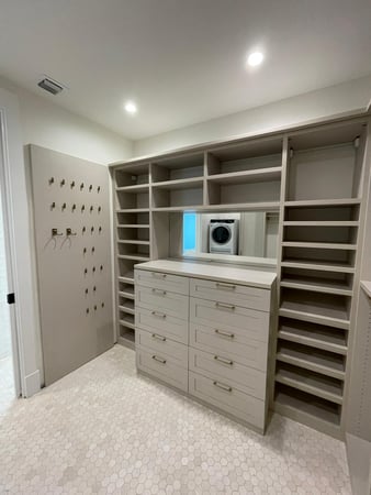 Perfect walk in closet with shelving, drawers and hooks on the wall for additional storage!