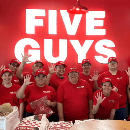 Employees pose for a photograph ahead of the grand opening of the Five Guys restaurant in Grand Junction, Colorado.