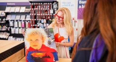 Customer picking up custom photo prints and a canvas wrap at FedEx Office.