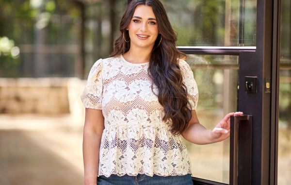 Woman is wearing a plus size lace peplum top.