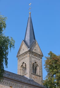 Kirchturm der Kirche vor blauem Himmel.
