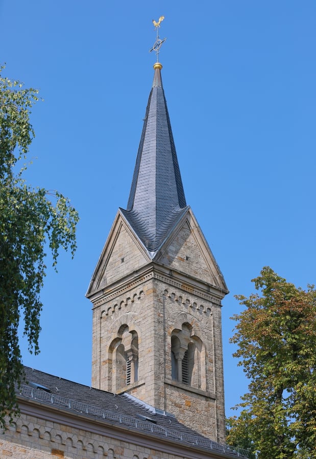 Kirchturm der Kirche vor blauem Himmel.
