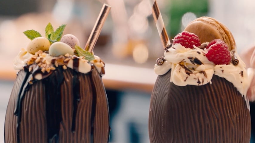 Easter eggs decorated with hazelnuts, mint leaves, raspberries, and macaroons