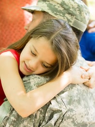 Military veteran hugging their daughter
