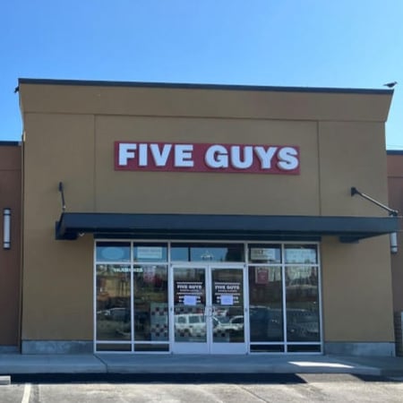 Exterior photograph of the Five Guys restaurant at 2600 Southwest Barton Street in Seattle, Washington.