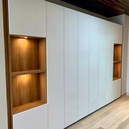 White wall unit with wood toned shelving for display