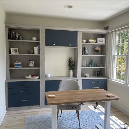 blue and grey office built-in with shelves, cabinets and desk with chair