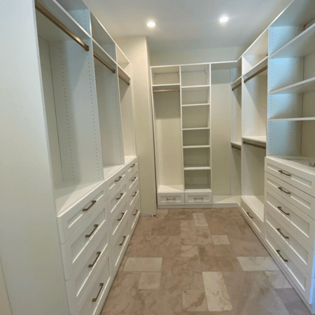 Luxe white walk-in closet with gold finishes