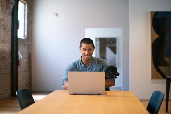 Man on laptop with dog