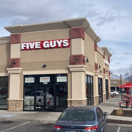 Exterior photograph of the Five Guys restaurant at 7168 S. Plaza Center Drive in West Jordan, Utah.