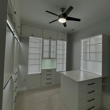 White walk-in closet with adjustable lighting.