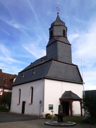 Wer die kleine Neesbacher Dorfkirche betritt, erlebt eine Überraschung: Decke und Wände werden von großflächigen Wandgemälden geschmückt. Die vier Evangelisten mit ihren Symbolen hinter Altar und Kanzel, überlebensgroß Jesus und Luther(!) an der Seitenwand und unter der Decke das Weltgericht. Vorher unter vielen Schichten Farbe verborgen, brachte die 1980 abgeschlossene Kirchenrestaurierung all das wieder zum Vorschein.
