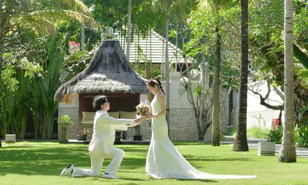 バリ島でウエディングドレス姿の新婦にブーケを渡すタキシード姿の新郎
