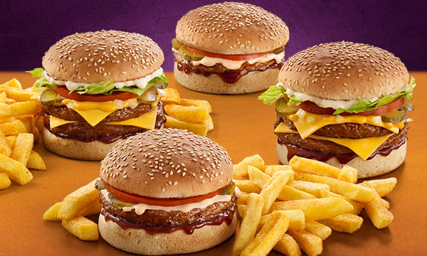 Four burgers with two portions of hand-cut chips between them against a purple background