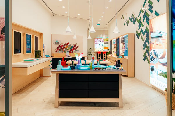 Imagem o interior de loja IQOS com equipamentos ILUMA