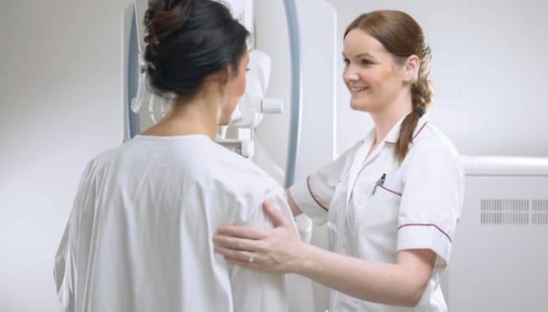 Radiologist talking patient through a breast mammogram