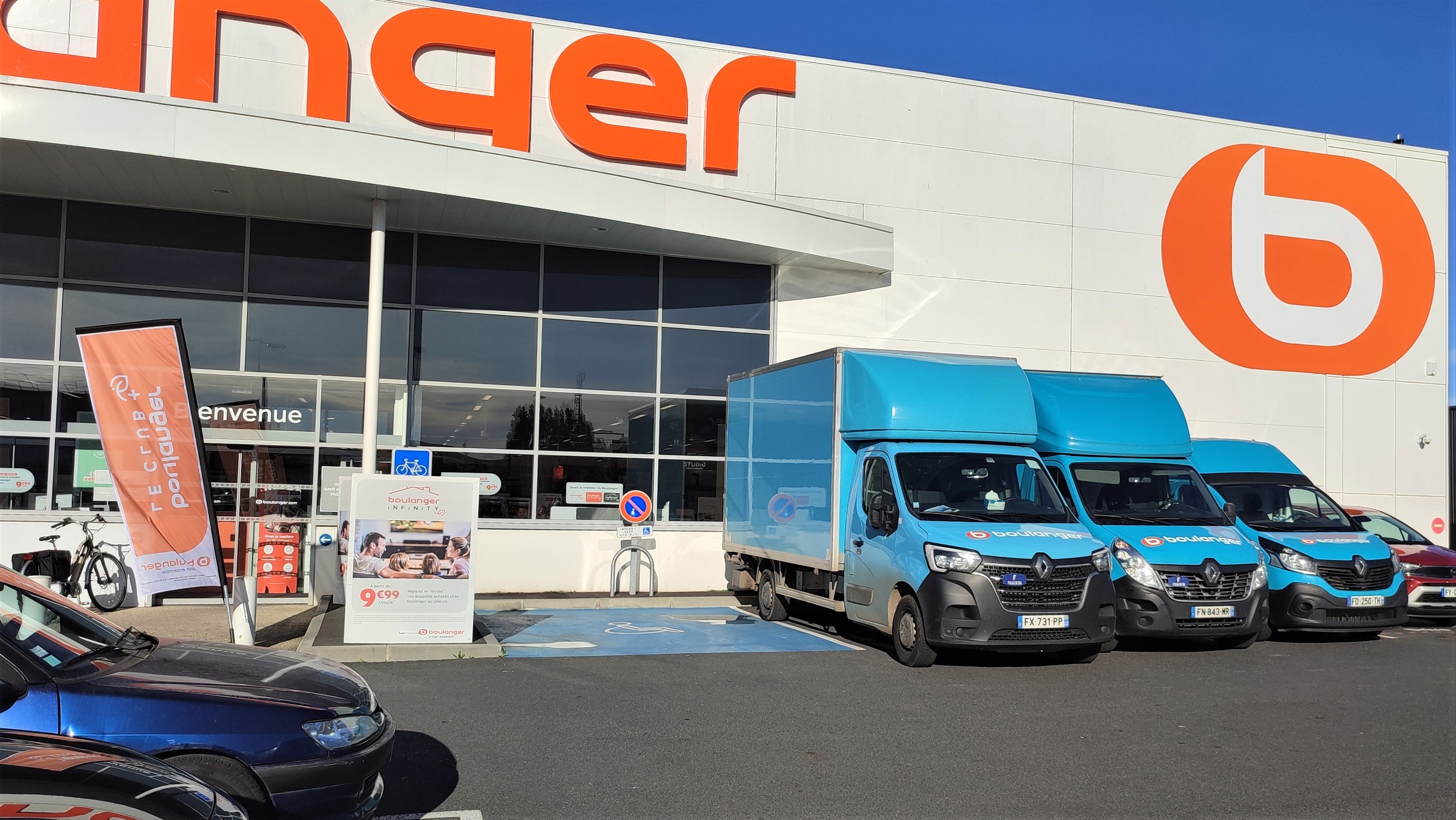 Photo de la devanture et des camions bleus des livreurs sur le parking de votre magasin Boulanger Saint Brieuc Langueux